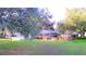 House nestled among lush trees, showcasing a large backyard at 2036 Lake Ariana Blvd, Auburndale, FL 33823