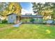 Gray house with a large yard and mature trees at 2036 Lake Ariana Blvd, Auburndale, FL 33823