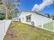 Spacious backyard with grassy area and white fence at 235 Lake Suzanne Dr, Lake Wales, FL 33859