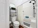 Clean bathroom with a shower/tub combo, toilet and shelving unit at 235 Lake Suzanne Dr, Lake Wales, FL 33859