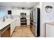 Bright kitchen featuring white cabinets, stainless steel appliances, and wood-look floors at 235 Lake Suzanne Dr, Lake Wales, FL 33859