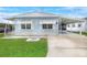 Light blue mobile home with carport and landscaped lawn at 6308 Bayberry Ne Blvd, Winter Haven, FL 33881