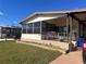 Mobile home exterior with covered porch, landscaping, and a pink flamingo decoration at 6447 Hollyberry Ne Ln, Winter Haven, FL 33881