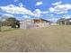 Tan mobile home with deck, landscaping, and a view of open space at 1750 Fox Hill Dr, Lakeland, FL 33810