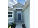 House entry with a blue door and walkway at 1218 Navel Rd, Bartow, FL 33830