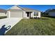 Newly constructed one-story home with attached garage and well-manicured lawn at 2169 Emma Ln, Lake Wales, FL 33859
