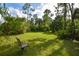 Serene backyard with a lawn and a single chair, ideal for relaxation at 213 Riverbend Rd, Ormond Beach, FL 32174