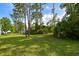 Large backyard with mature trees and open grassy area at 213 Riverbend Rd, Ormond Beach, FL 32174