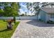 A long brick-paved driveway leading to a light teal house with white fence at 213 Riverbend Rd, Ormond Beach, FL 32174