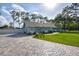 Charming teal home with a brick-paved driveway, a well-manicured lawn, and mature trees at 213 Riverbend Rd, Ormond Beach, FL 32174