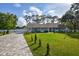Single-story home with light teal exterior, new landscaping, and a paved driveway at 213 Riverbend Rd, Ormond Beach, FL 32174