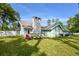 House exterior with stone chimney and lounge chairs at 213 Riverbend Rd, Ormond Beach, FL 32174