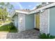 Front entrance with a yellow door and stone detailing at 213 Riverbend Rd, Ormond Beach, FL 32174