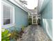 Charming side patio walkway with brick pavers and plants at 213 Riverbend Rd, Ormond Beach, FL 32174