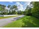 Quiet street lined with trees and houses; showcasing curb appeal at 213 Riverbend Rd, Ormond Beach, FL 32174