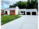Charming ranch home with white and wood siding, a two-car garage, and a landscaped lawn at 210 W Illiana St, Orlando, FL 32806