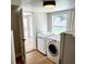 Bright laundry room with washer, dryer, and access to backyard at 210 W Illiana St, Orlando, FL 32806