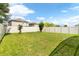 Fenced backyard with grassy lawn and mature trees at 2720 Monticello Way, Kissimmee, FL 34741