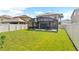 Large backyard with grassy lawn and screened patio at 2720 Monticello Way, Kissimmee, FL 34741