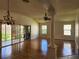 Bright living room with hardwood floors, vaulted ceiling, and sliding glass doors at 1889 Blythewood Loop, The Villages, FL 32162