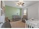Bedroom with crib, rocker, and changing table at 2557 Shamrock St, Tavares, FL 32778
