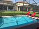 Screened pool and spa with red lounge chairs at 1402 Wexford Way, Davenport, FL 33896