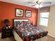 Bedroom with queen bed, floral bedding, and orange walls at 1402 Wexford Way, Davenport, FL 33896