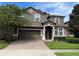 Two-story house with a brown facade and brick driveway at 1402 Wexford Way, Davenport, FL 33896