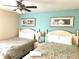 Bedroom with two double beds, ceiling fan and teal walls at 1402 Wexford Way, Davenport, FL 33896