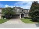 Two-story house with a brown facade and brick driveway at 1402 Wexford Way, Davenport, FL 33896