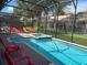 Screened pool and spa with red lounge chairs at 1402 Wexford Way, Davenport, FL 33896