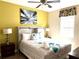 King-size bed, ceiling fan, and yellow accent wall at 1402 Wexford Way, Davenport, FL 33896