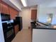 Clean and efficient kitchen with wood cabinets and black appliances at 7395 Universal Blvd # 904, Orlando, FL 32819