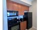 Modern kitchen featuring black appliances and wood cabinetry at 7395 Universal Blvd # 904, Orlando, FL 32819