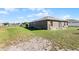 Spacious backyard with grassy area and partial view of the home's exterior at 7878 Tanbier Dr, Orlando, FL 32818