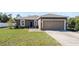 House exterior featuring a two-car garage and well-maintained lawn at 7878 Tanbier Dr, Orlando, FL 32818