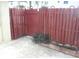 Small backyard with a red wooden fence and gate at 6274 Whispering Way # 130, Orlando, FL 32807