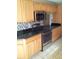 Kitchen features wood cabinets, granite countertops, and stainless steel appliances at 6274 Whispering Way # 130, Orlando, FL 32807