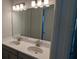 Double vanity bathroom with modern lighting and large mirror at 3937 Reed Grass Pl, Kissimmee, FL 34746