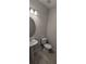 Powder room with pedestal sink, toilet, and round mirror at 3937 Reed Grass Pl, Kissimmee, FL 34746