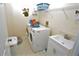 Convenient laundry room with washer, dryer, sink, and shelving at 13900 Fox Glove St, Winter Garden, FL 34787