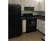 Galley kitchen with black appliances and white cabinets at 600 Northern Way # 108, Winter Springs, FL 32708