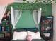 Bedroom with canopy bed, green walls, and ample shelving at 924 Derbyshire Dr, Kissimmee, FL 34758