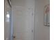 Simple hallway with a six-panel door and wall art at 924 Derbyshire Dr, Kissimmee, FL 34758