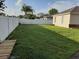 Side yard with grassy area and white vinyl fence at 924 Derbyshire Dr, Kissimmee, FL 34758