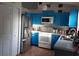 Bright kitchen with blue cabinets, stainless steel appliances, and tile flooring at 924 Derbyshire Dr, Kissimmee, FL 34758
