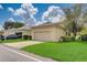 House exterior showcasing a tan garage and lawn at 6943 Cupseed Ln, Harmony, FL 34773