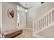Bright foyer with tiled floors, bench, mirror, and staircase at 6943 Cupseed Ln, Harmony, FL 34773