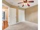 Bedroom with ceiling fan, carpet, and access to hallway at 6943 Cupseed Ln, Harmony, FL 34773