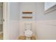 Simple and clean bathroom with white toilet and wood shelves at 6943 Cupseed Ln, Harmony, FL 34773